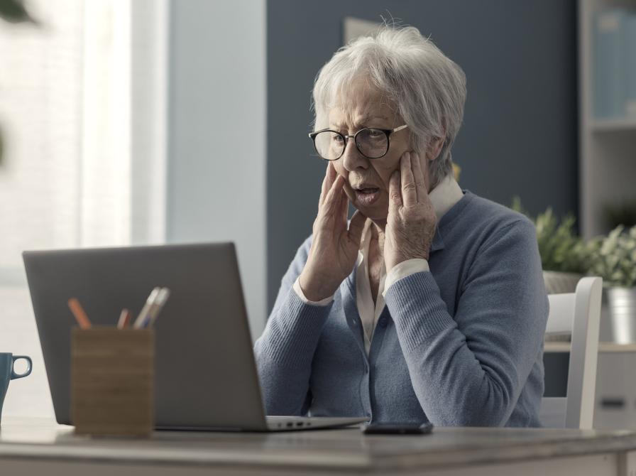 Frustreret dame sidder foran sin computer